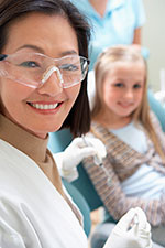 smiling dentist with child in chair